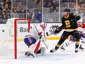 Charlie Coyle (13) of the Bruins scores a goal during the third period against Canadiens goalkeeper Samuel Montembeault at the TD Garden in Boston on Sunday, Nov. 14, 2021.