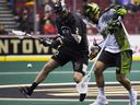 Matt Beers (2) of the Vancouver Warriors and Jeremy Thompson of Saskatchewan Rush search for a fumble in a NL regular season game at Vancouver's Rogers Arena on January 12, 2019.