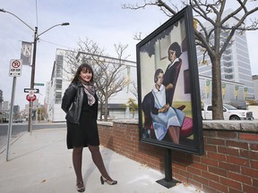 Jennifer Matotek, Executive Director of the Art Gallery of Windsor, stands next to a weatherproof life-size reproduction of a painting from the AGW Collection, mounted in downtown Windsor.  Photographed November 11, 2021.