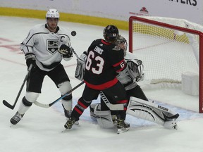 Kings goalkeeper Jonathan Quick can't find the puck as he bounces between teammate Anze Kopitar and Senators forward Tyler Ennis in the first period Thursday night.