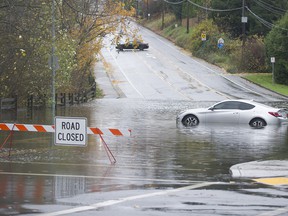 A car is found in a pool of water at the closed intersection of Old Yale Road and Mitchell Street in Abbotsford on November 15, 2021. Two days of rain flooded, closed or washed away many roads in the Lower Mainland and Fraser Valley.