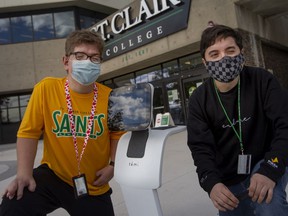 St. Clair College students in the CICE program, Kyle Schauer, left, and Evan Fairlie, are photographed with an interactive robot that was introduced to the program this semester, Tuesday, November 2, 2021.