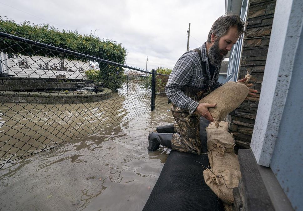 People carry sandbags to try to stop rising floodwaters in Barrowtown on Friday.