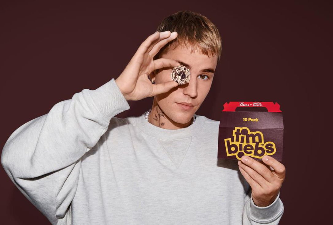 Justin Bieber holds up a packet of the new Timbit flavors from Tim Hortons, called Timbiebs in this undated photo from the brochure.  Tim Hortons has teamed up with pop superstar Justin Bieber to launch three new flavors of Timbit, called Timbiebs, along with co-branded products.