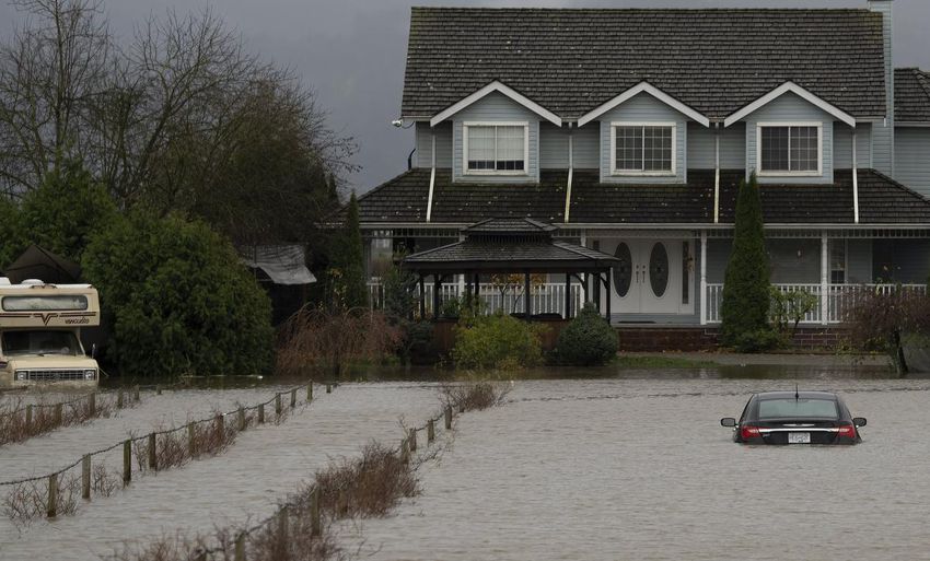 A vehicle dives into flood waters along a road in Abbotsford, BC