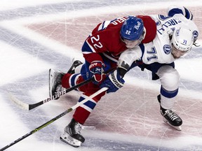 Montreal Canadiens right wing Cole Caufield (22) leans on Tampa Bay Lightning center Anthony Cirelli (71) during Game 4 of the Stanley Cup final in Montreal on Monday, July 5, 2021 .