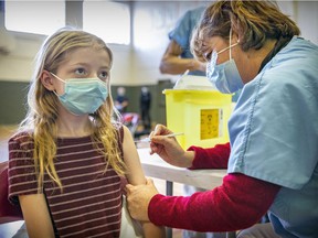 Katherine Love, 11, of Beaconsfield is vaccinated against COVID-19 at a clinic for children ages 5 to 11 held at the Beurling Academy in Verdun on November 27.