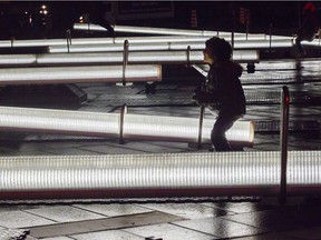 Gabriel Colley-King plays with the illuminated seesaw, part of an installation called Impulsion, in the 12th edition of Luminothérapie in the Quartier des Spectacles.