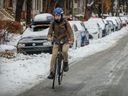 Yohei Mercier rides her bike down a slippery Melrose Ave. in the Notre-Dame-de-Grace district after the first significant snowfall of the season in Montreal, on December 6, 2021.