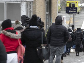 People wait in line on Plessis St. to be admitted to the COVID testing clinic at Notre-Dame Hospital on December 22, 2021.