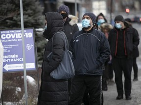 People wait in line at a COVID-19 vaccination clinic on Parc Ave December 29, 2021.