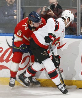 Owen Tippett # 74 of the Florida Panthers and Zach Sanford # 13 of the Ottawa Senators battle for the puck across the boards during the first period.