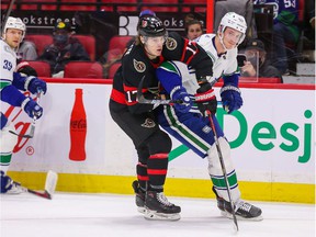 Adam Gaudette of the Ottawa Senators fights for position with Tyler Myers of the Vancouver Canucks during the second period at the Canadian Tire Center on December 1, 2021 in Ottawa, Ontario.