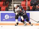 It's a No. 27 battle as Vancouver Giants defender Alex Cotton tries to stop American Tai-City winger Rhett Melnyk in a battle for the puck on Friday in Kennewick, Washington.