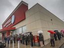 Customers line up for a vaccine clinic at a Shoppers Drug Mart in Amherstburg, Ontario, on December 18, 2021.