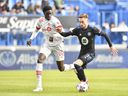Djordje Mihailovic of CF Montréal controls the ball against Noble Okello of Toronto FC in the first half during the 2021 Canadian Championship Final at Stade Saputo on November 21, 2021 in Montreal.
