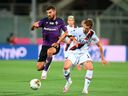Patrick Cutrone of Fiorentina, left, and Gabriele Corbo of Bologna compete for the ball during a Serie A soccer match between Fiorentina and Bologna, at Artemio Franchi Stadium in Florence, Italy, Wednesday July 29, 2020.