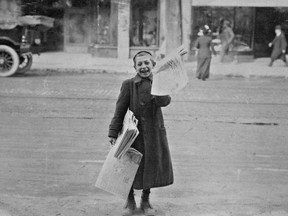 A smiling newspaper boy on the streets of Montreal, around 1900.