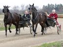 Dave Bain, left, in the sulky with Smile In Style and Tom Bain behind Tilly Dreamcatcher exercise their horses in South Woodslee on Thursday, April 23, 2020. 