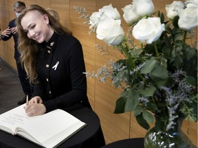 Willow Dew signs the golden book during the White Rose ceremony at the Polytechnique Montréal on Thursday, December 2, 2021.