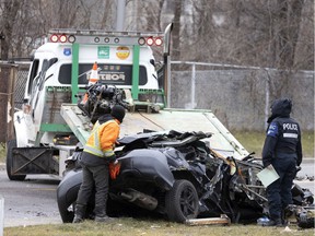 Montreal police and towing crews remove a car that lost control and overturned near the Sources Blvd.-Highway 20 overpass on Saturday, December 18, 2021.