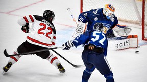 Canadian forward Landon Ferraro (L) attacks Finnish goalkeeper Christian Heljanko's net during the Euro Hockey Tour Channel One Cup ice hockey match between Canada and Finland at CSKA Arena in Moscow on December 18, 2021.
