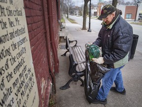 Nick Peters cleans up trash in Olde Sandwich Town as part of a cleanup effort led by Hands in Hands Support and in collaboration with Jubzi Inc. on December 11, 2021.
