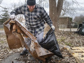Charles Bell cleans up litter in Olde Sandwich Town as part of a cleanup effort led by Hands in Hands Support and in collaboration with Jubzi Inc. on December 11, 2021.