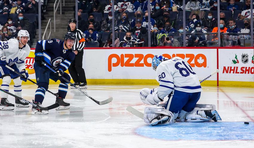 Winnipeg's Andrew Copp takes a shot between the pads of Leafs goalkeeper Joseph Woll during a high-scoring second period Sunday.  The Jets scored four goals in a row to open the period.