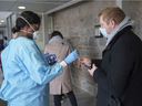 A nurse hands over a swab for a rapid COVID-19 self-test at a testing clinic in Montreal, Wednesday, Dec. 15, 2021.