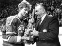 Wayne Gretzky of the Edmonton Oilers receives a woodcarving from former great Maurice Richard of the Montreal Canadiens in Montreal on March 2, 1982.