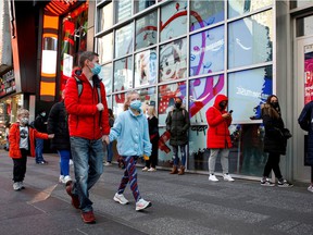 People wear protective masks to enter a store as New York State's new indoor masking mandates went into effect amid the spread of coronavirus disease (COVID-19) in New York City, USA. December 14, 2021.
