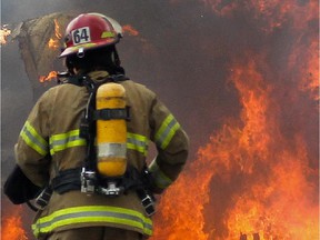 A firefighter walks towards a fire.