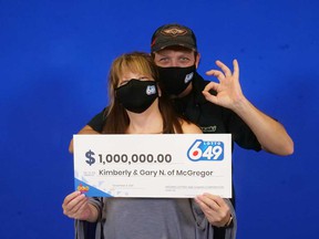 McGregor's Kimberly and Gary Noel hold up their $ 1 million prize check from the Lotto 6/49 drawing on November 27, 2021.