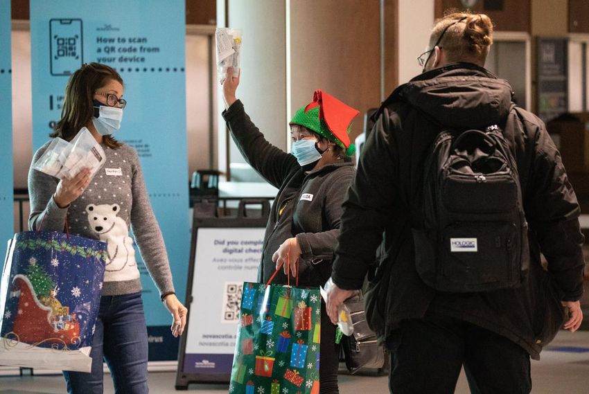 Welcome to Halifax?  here's your rapid COVID test.  Volunteer Imelda Montinola, along with Heather Patterson, left, hand out test kits to passengers at the airport Tuesday.