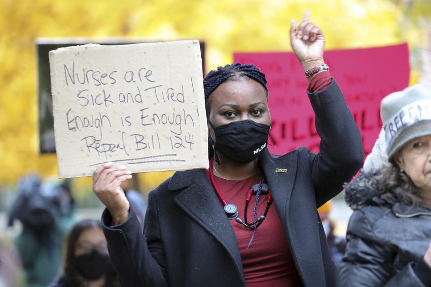 Nurse Birgit Umaigba listens to speeches and shows her support at a protest in Toronto's Nathan Phillips Square.