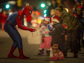 Spiderman hands out treats to children during the 53rd Annual Windsor Santa Claus Parade, Saturday, Dec. 4, 2021.