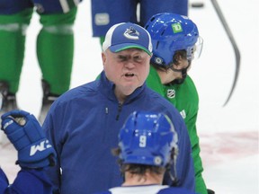 New Canucks head coach Bruce Boudreau delivers his message to veteran forward JT Miller during team practice Tuesday at Rogers Arena.