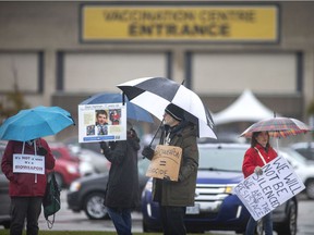 The vaccination center and other health personnel have become targets of harassment, threats and worse.  In this Nov.25, 2021 photo, opponents of COVID-19 vaccines protest outside the Devonshire Mall vaccination center on the first day children ages five to 11 became eligible for the vaccine.