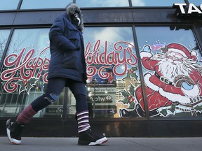 A pedestrian walks past a Christmas season mural in downtown Windsor on December 22, 2021.