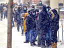 People wait in line during a snowstorm outside the COVID-19 testing center on Park Ave in Montreal on Tuesday, December 28, 2021. Difficulties accessing testing, and now, restrictions on who can obtain data from PCR means that case numbers are a problem.  underestimate.