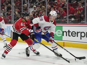 The Canadiens' Christian Dvorak controls the puck against the Blackhawks' Riley Stillman during the first period Thursday night in Chicago.