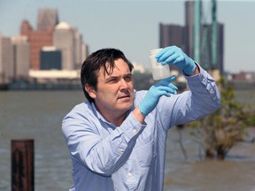Mike McKay, executive director of the Great Lakes Environmental Research Institute, takes samples of sewage from the Detroit River in this 2020 file photo. McKay and his team at the University of Windsor are studying sewage discharge to monitor the COVID-19.