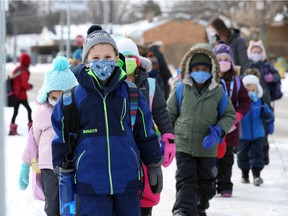 Shown here nearly a year ago, on February 8, 2021, students at St. John Vianney Catholic Elementary School make their way to school buses after their first day back at school.