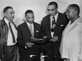 Civil rights leader the Rev. Martin Luther King Jr. was a guest speaker on August 7, 1956, at the Emancipation Day celebrations in Jackson Park.  From left, discussing the program, are Russel Small of Windsor, chairman of the Emancipation committee;  King;  Rev. Theodore S. Boone of Detroit;  and Walter Perry, founder and organizer of the Emancipation Celebration.