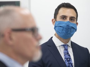 In this file photo from November, Ontario Minister of Education Stephen Lecce looks on as Dr. Kieran Moore, Ontario's chief medical officer, at a news conference in Toronto.