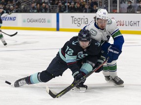 Quinn Hughes (right), leaning on Seattle Kraken winger Joonas Donskoi, during last Saturday's game in Seattle, has been concentrating on his defensive play since last offseason.  