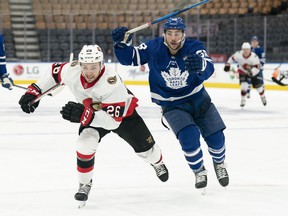 Ottawa Senators defender Erik Brannstrom (26) and Toronto Maple Leafs left wing Michael Bunting (58) chase the puck during the third period at Scotiabank Arena on January 1, 2022.