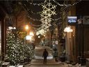 A lone man walks through the old historic Champlain district in Quebec City, less than two minutes before the start of the curfew at 10 p.m. on December 31, 2021.