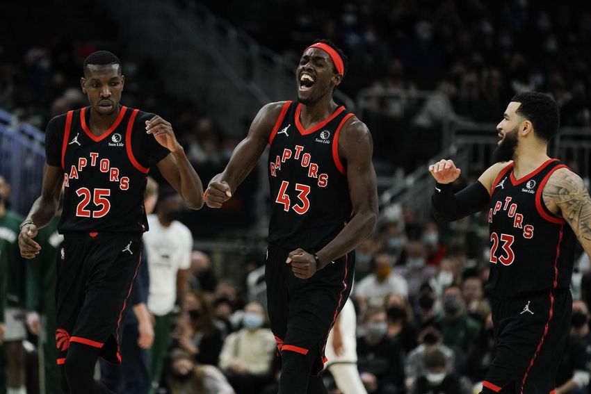 Toronto Raptors' Pascal Siakam celebrates with teammates Chris Boucher (25) and Fred VanVleet (23) in a last-minute victory over the Milwaukee Bucks on Saturday.